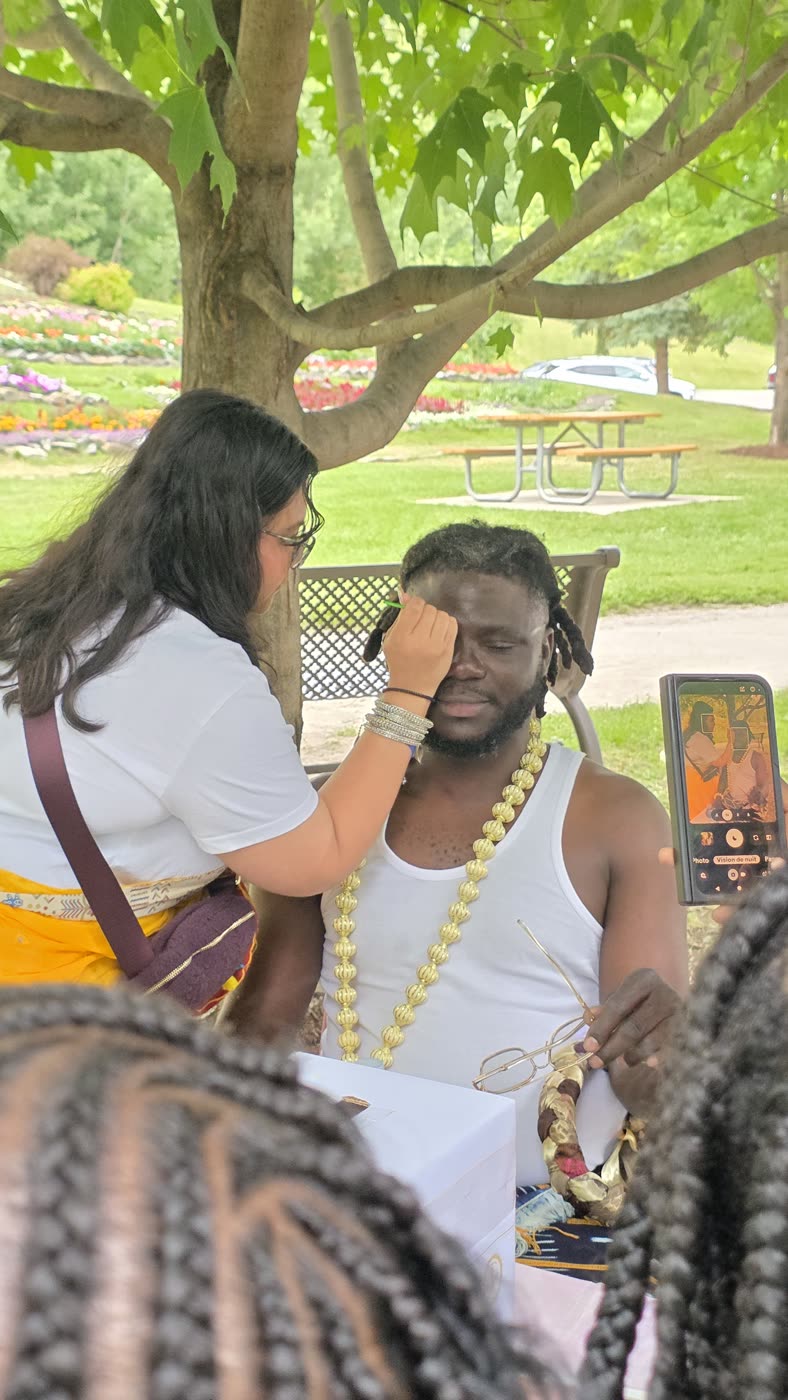 A devotee offering tilaka to a guest