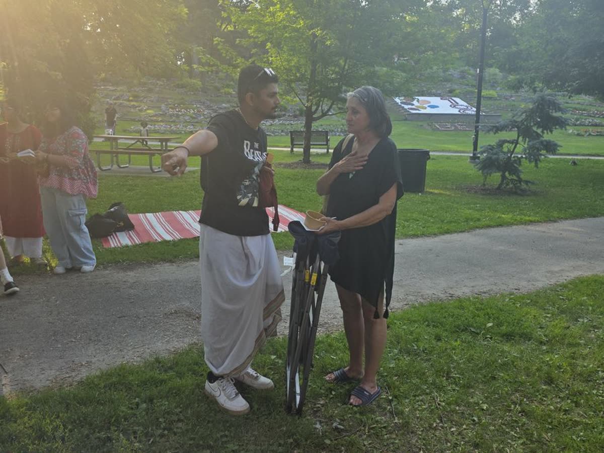 A Sudbury Bhakti Centre devotee in warm conversation with a visitor at Bell Park
