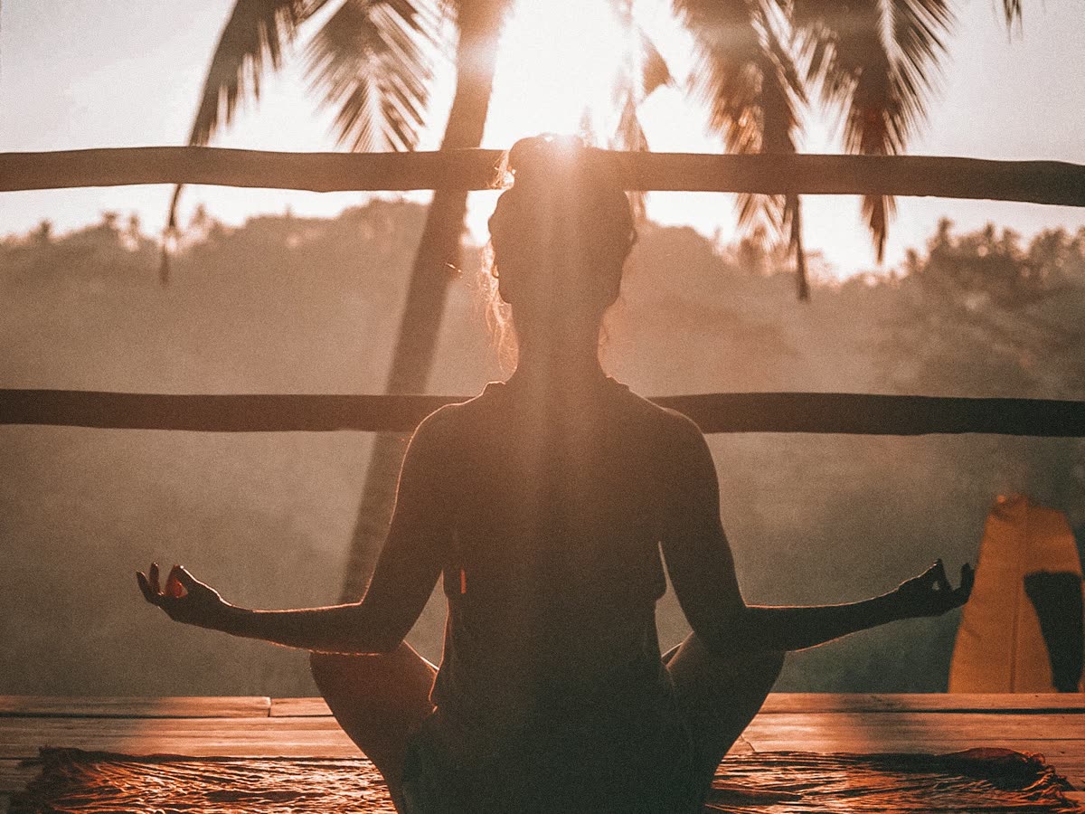 A person in calm seated meditation at sunrise